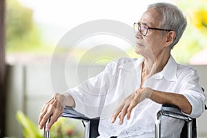 Scowling senior woman sitting and looking outside,waiting for her family,serious old elderly with frowning face,expression of