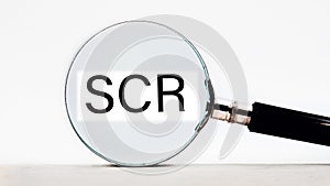 scr lettering on through a magnifying glass on a light background