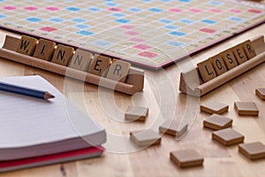 Scrabble board game with the scrabble tile spell `Winner Loser`