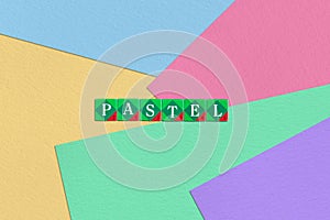 Scrabble letters spelling pastel on colorful paper background photo
