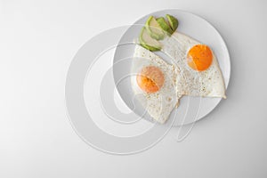 Scrambled eggs with avocado and specialy on a white plate on a white background with blank copy space, top view