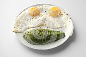 Scrambled eggs with avocado and specialy on a white plate on a white background. Close-up, top view