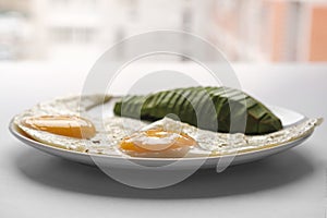 Scrambled eggs with avocado and specialy on a white plate on a white background, closeup