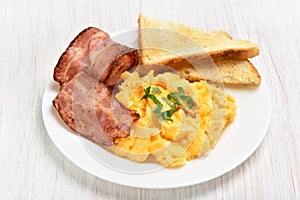 Scrambled eggs with bacon and toasts