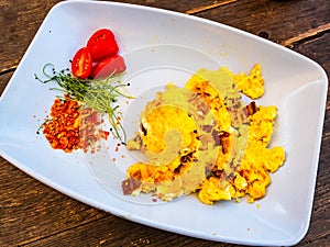 Scrambled eggs for breakfast with some raw vegetables