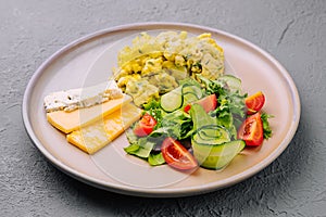 Scrambled eggs with cheese and tomato and cucumber salad