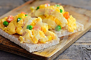 Scrambled eggs omelette. Homemade scrambled eggs omelette with vegetables on crispy bread toasts. Healthy eating. Rustic style