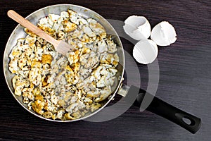 Scrambled eggs in a pan focus at center of pan