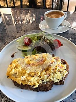 Scrambled Eggs with Sourdough Bread, Cheddar Cheese, Bacon Slices served with Salad