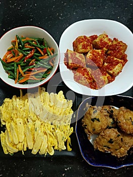 Scrambled eggs telur dadar spicy fried tofu fried mashed potatoes perkedel and stir fry green bean with carrot