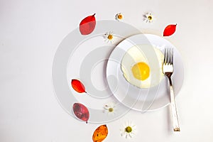 Scrambled eggs on a white plate and a bright white table