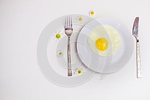 Scrambled eggs on a white plate and a bright white table