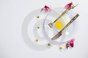 Scrambled eggs on a white plate and a bright white table