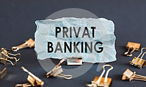 A scrap of blue paper with clips on a gray background with the text - PRIVAT BANKING