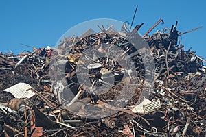 Scrap heap of rusty steel, aluminium under blue sky prepared to be recycled