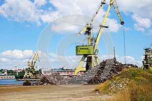 Scrap metal yard and crane on seaport, recycling materials