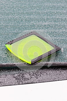 Scraper using to scrape ice from car window, winter problems in transportation concept