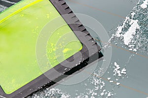 Scraper using to scrape ice from car window, winter problems in transportation concept