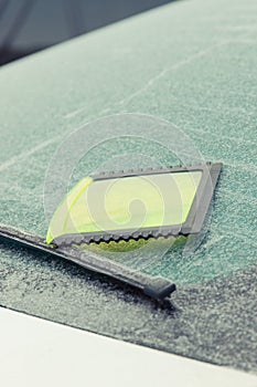 Scraper using to scrape ice from window in car, winter problems concept