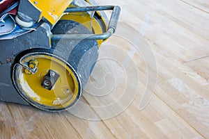 Scraping machine or grinder for the process of scraping wood parquet or other type of floor stands at just laid parquet and ready