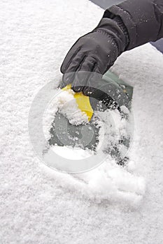 Scraping snow from the car windscreen