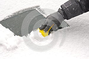 Scraping snow from the car windscreen