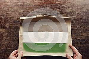 On the scratched table lies an old, tattered piece of paper with a picture of the naturist flag