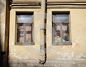 The scratched wall of old scary house at Dostoevsky street with to windows.