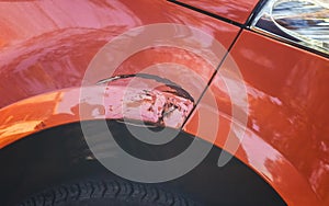 Scratching on the front of the car`s wing in a car repair shop