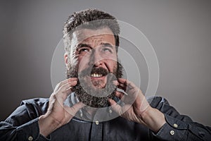 Scratching huge beard portrait, mature adult Caucasian man