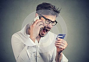 Screaming angry man solving problems with credit card