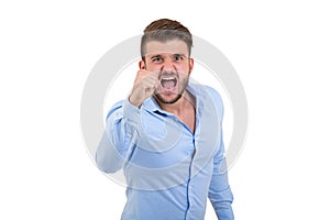 Screaming angry young bearded emotional man standing over white wall background isolated.