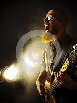 Screaming bass player in front of spotlight