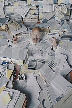 Screaming businessman drowning under a lot of paperwork