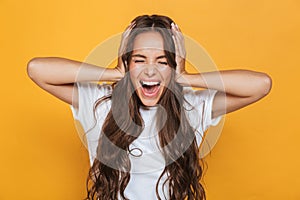 Screaming emotional young woman isolated over yellow background.