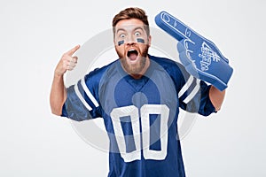 Screaming excited man fan in blue t-shirt standing isolated