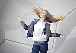 Screaming furious aggressive brunette woman with flying long hairs, flash studio portrait on modern wall