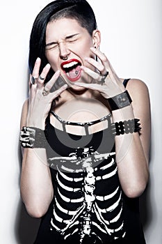 Screaming Girl with shaved head and blue hair in art gothic style with gothic accessories.