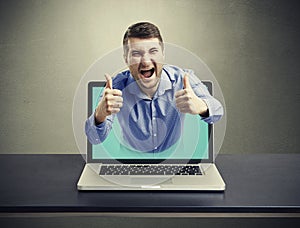 Screaming happy man got out of the laptop