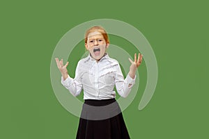 The young emotional angry teen girl screaming on green studio background