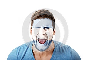 Screaming man with Argentina flag on face.