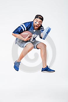 Screaming man fan in blue t-shirt jumping isolated