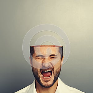 Screaming man with open head over grey