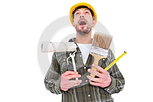 Screaming manual worker holding various tools