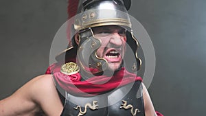Screaming violent roman soldier pulls out his sword and points it