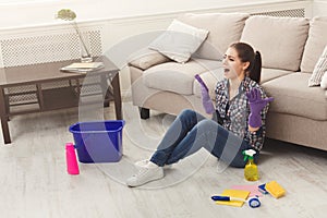 Screaming woman cleaning floor with lots of tools