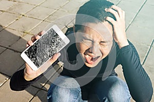 Screaming woman holding a screen crack the smartphone