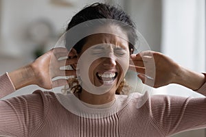 Screaming woman plug up with fingers ears annoyed by noise