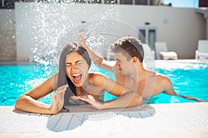 Screaming young teenage girl at the pool annoyed with pool splashing.Splashing water and playing games at the pool,having fun