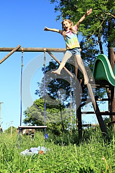 Screeming girl jumping from a slide photo